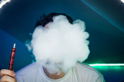 Close-up of young man smoking in club