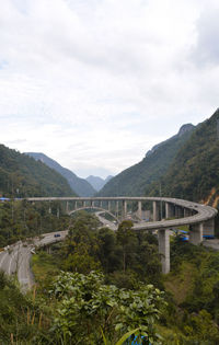 Bridge over mountains against sky