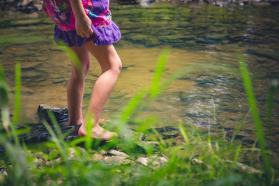 Low section of woman standing on field