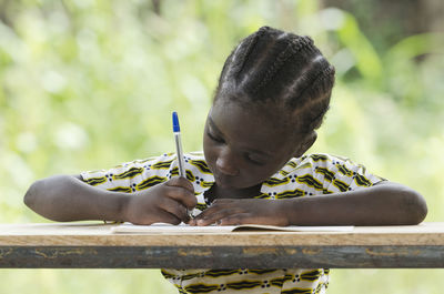 Close-up of girl writing in book