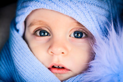 Close-up portrait of cute baby boy in purple warm clothing