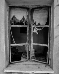 Close-up of broken window of old building