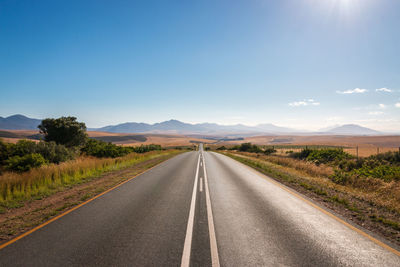 Road passing through landscape against sky