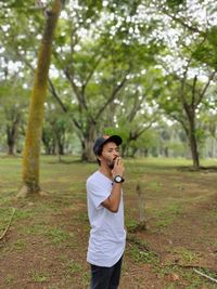 Man smoking cigarette while standing at park