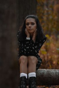 Portrait of young woman standing on field