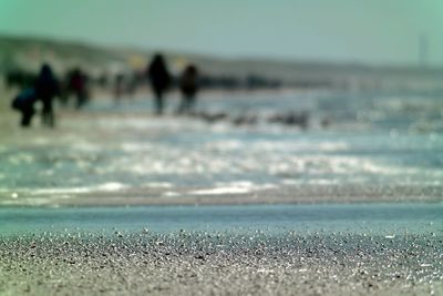 People at beach against sky