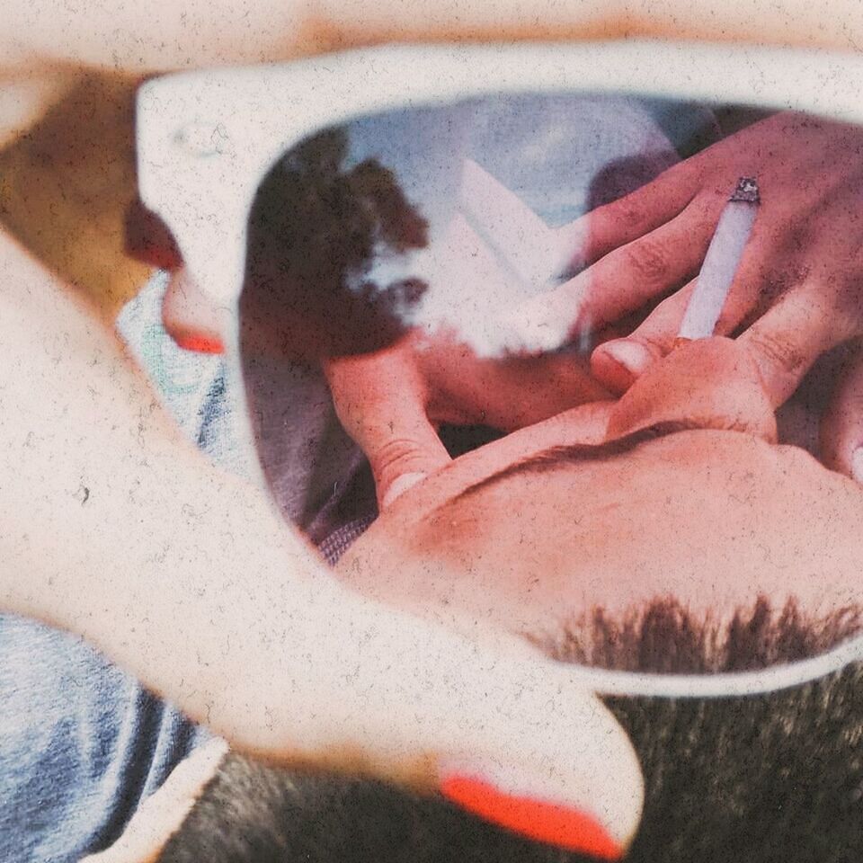 CLOSE-UP OF HAND TOUCHING CAT LYING ON HUMAN FINGER