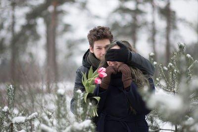 Young couple standing in forest during winter