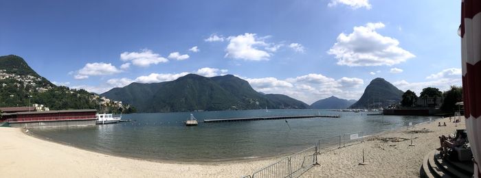 Scenic view of bay and mountains against sky