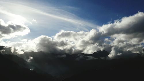 Scenic shot of clouds over silhouette mountain range