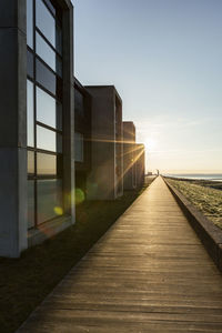 Denmark, romo, boardwalk along row of modern summer houses at sunset