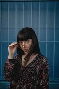 Portrait of woman standing against wall