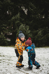 Kids having fun outside at park playing in snow on winter day europe