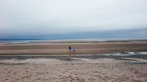 People on beach against sky