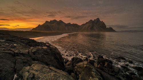 Scenic view of sea against sky during sunset at vestrahorn, iceland