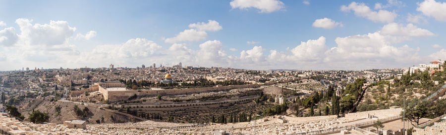 Panoramic view of cityscape against cloudy sky