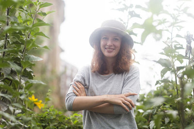 Young woman with summer hat outside in an urban garden