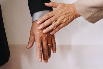 Midsection of mature couple holding hands