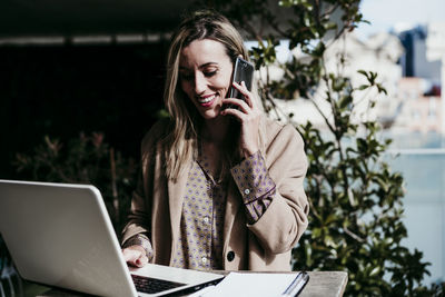 Young woman using mobile phone outdoors