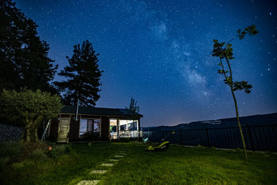 House on field against sky at night