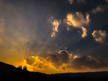 Low angle view of silhouette mountain against dramatic sky