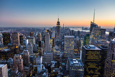 Aerial view of buildings in city at sunset