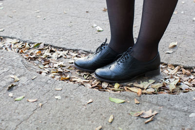 Low section of woman standing on footpath