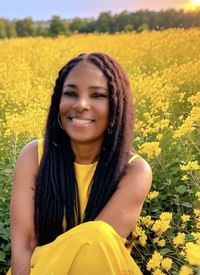 Close-up of woman standing amidst yellow flowering plants on field