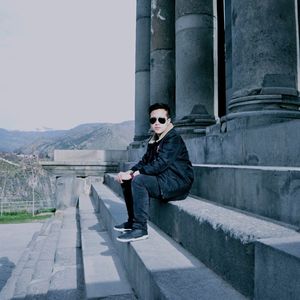 Full length side view of mature man sitting on concrete floor