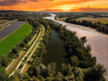 High angle view of road amidst trees against sky during sunset