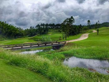 Scenic view of grassy field against cloudy sky