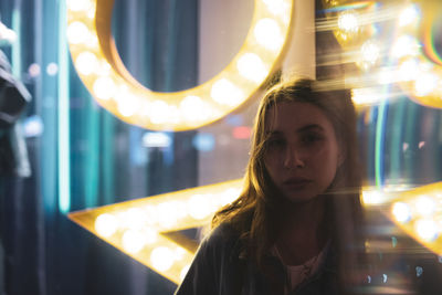 Close-up portrait of young woman with illuminated lights