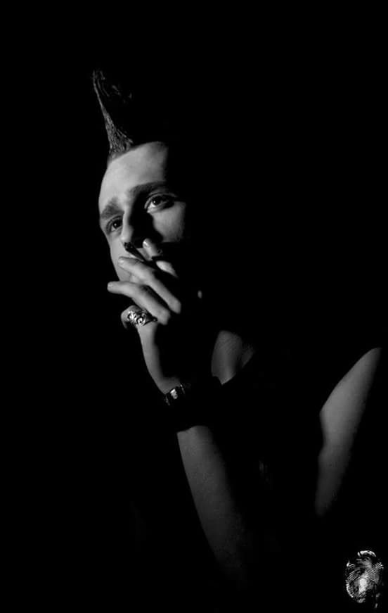 CLOSE-UP OF WOMAN WITH HAND ON HAIR AGAINST BLACK BACKGROUND