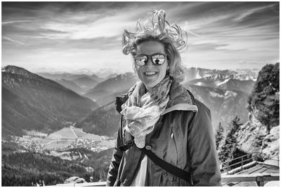 Portrait of smiling woman on snow covered mountains against sky