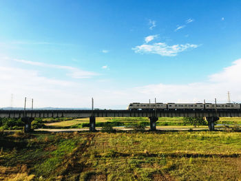 Bridge over field against sky