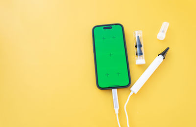 Directly above shot of usb stick against yellow background