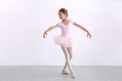 Full length of woman dancing against white background