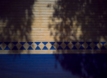 Shadow of wall on tiled floor