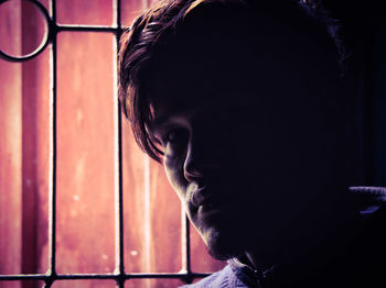 Close-up of young man by window at home