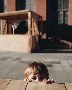 Rear view of boy sitting on footpath