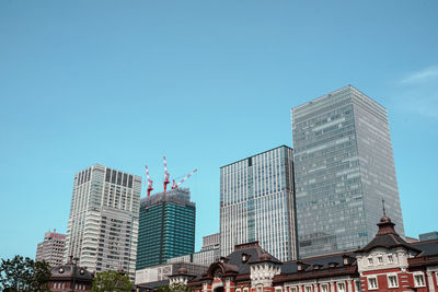 Low angle view of modern buildings against clear blue sky