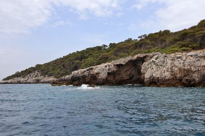 Rock formations by sea against sky