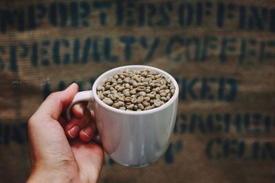 Close-up of hand holding coffee cup