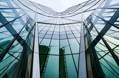 Low angle view of glass building against sky