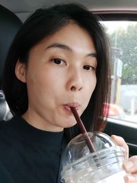 Close-up portrait of a boy drinking glass