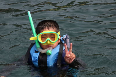 Portrait of boy gesturing while swimming in sea