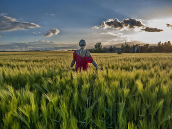 Rear view of man standing on grassy field