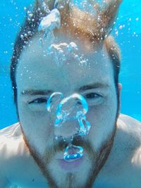 Close-up portrait of young man swimming undersea