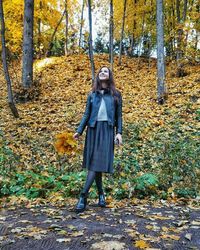 Full length portrait of woman standing in forest