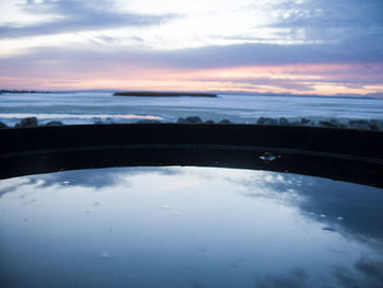 Reflection of clouds in sea at sunset